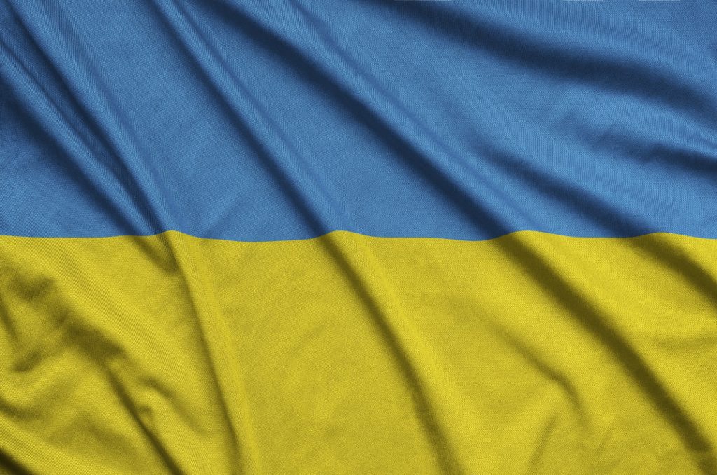 Ukraine flag is depicted on a sports cloth fabric with many folds. Sport team waving banner